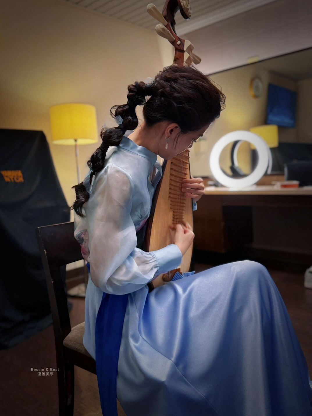 後台梳化室環形燈光映照・演奏家右手高速輪指掃拂之動態美感，泡泡編織辮造型立體飽滿
